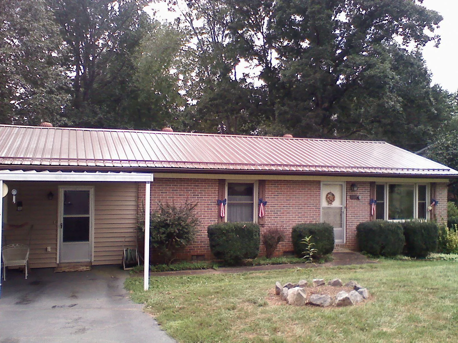 Bronze metal roof and carport on a brick ranch home — Roof Repair work by our crew in Poplar Grove